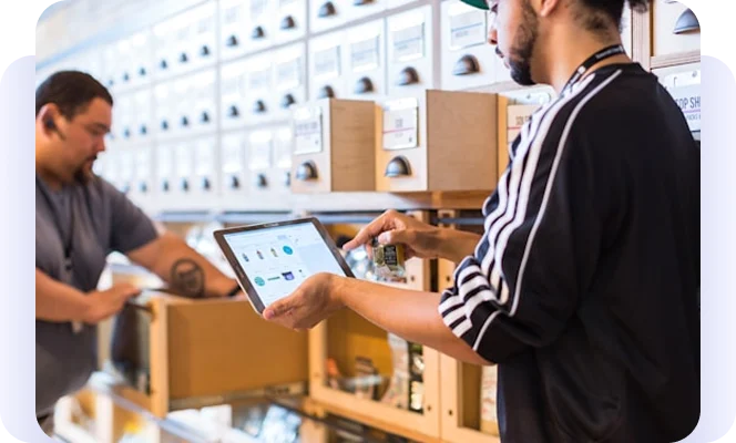 Warehouse employees using a tablet to manage inventory.