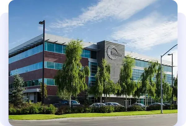 Bristol Bay office building with glass windows and trees in front.