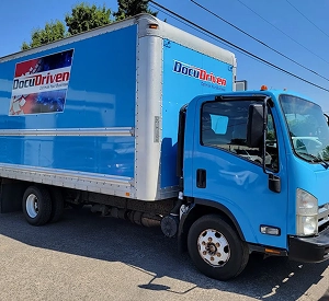 Blue box truck parked outdoors.