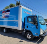 Blue box truck parked outdoors.