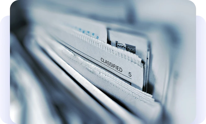 Close-up of classified paper files in a filing cabinet.
